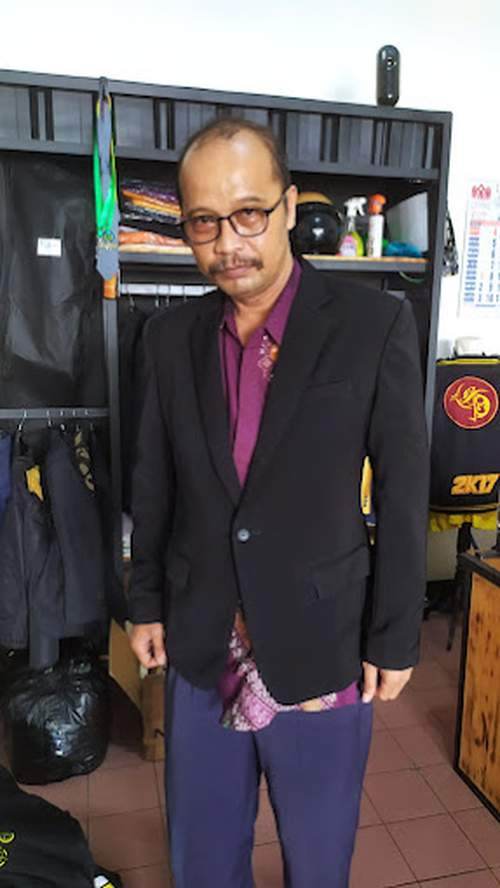 Pelanggan MENSWEAR Mens Apparel mencoba jas custom navy di ruang fitting