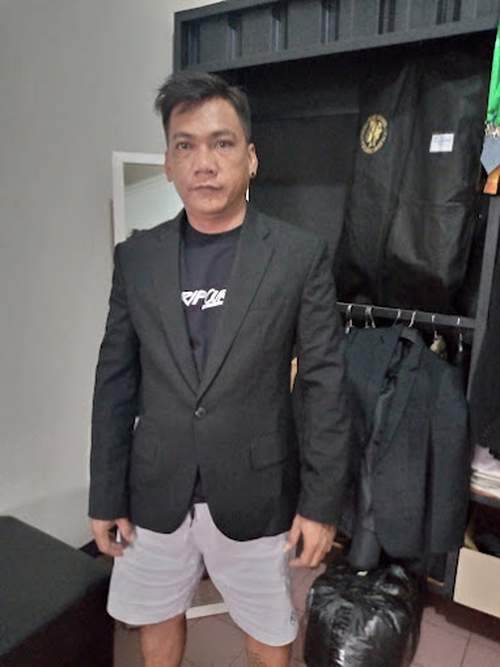 Pelanggan MENSWEAR Mens Apparel mencoba jas custom hijau tua di ruang fitting