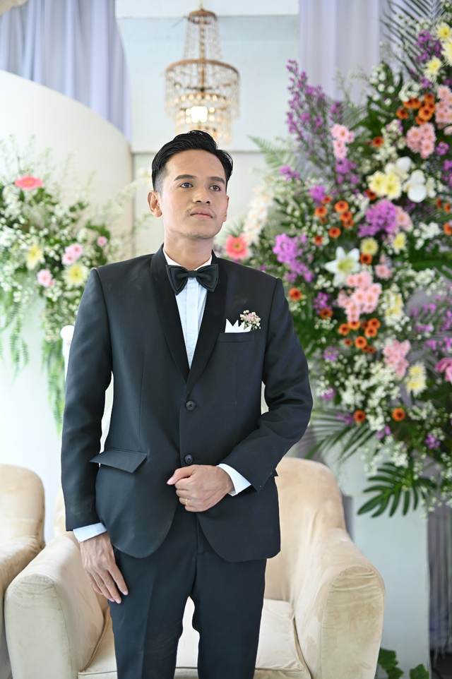 Rizky, pelanggan MENSWEAR Mens Apparel, mengenakan jas custom hitam saat resepsi pernikahan